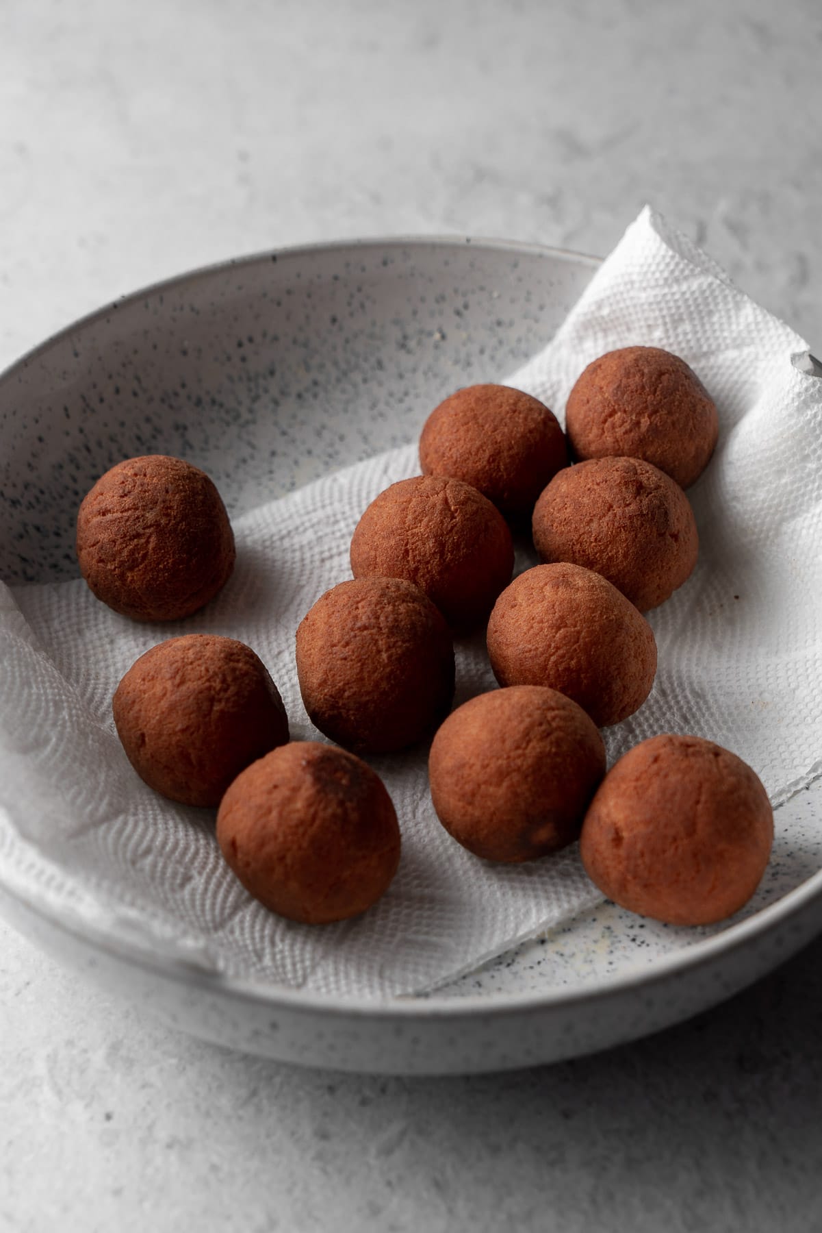 fried gulab jamun in a bowl on a paper towel