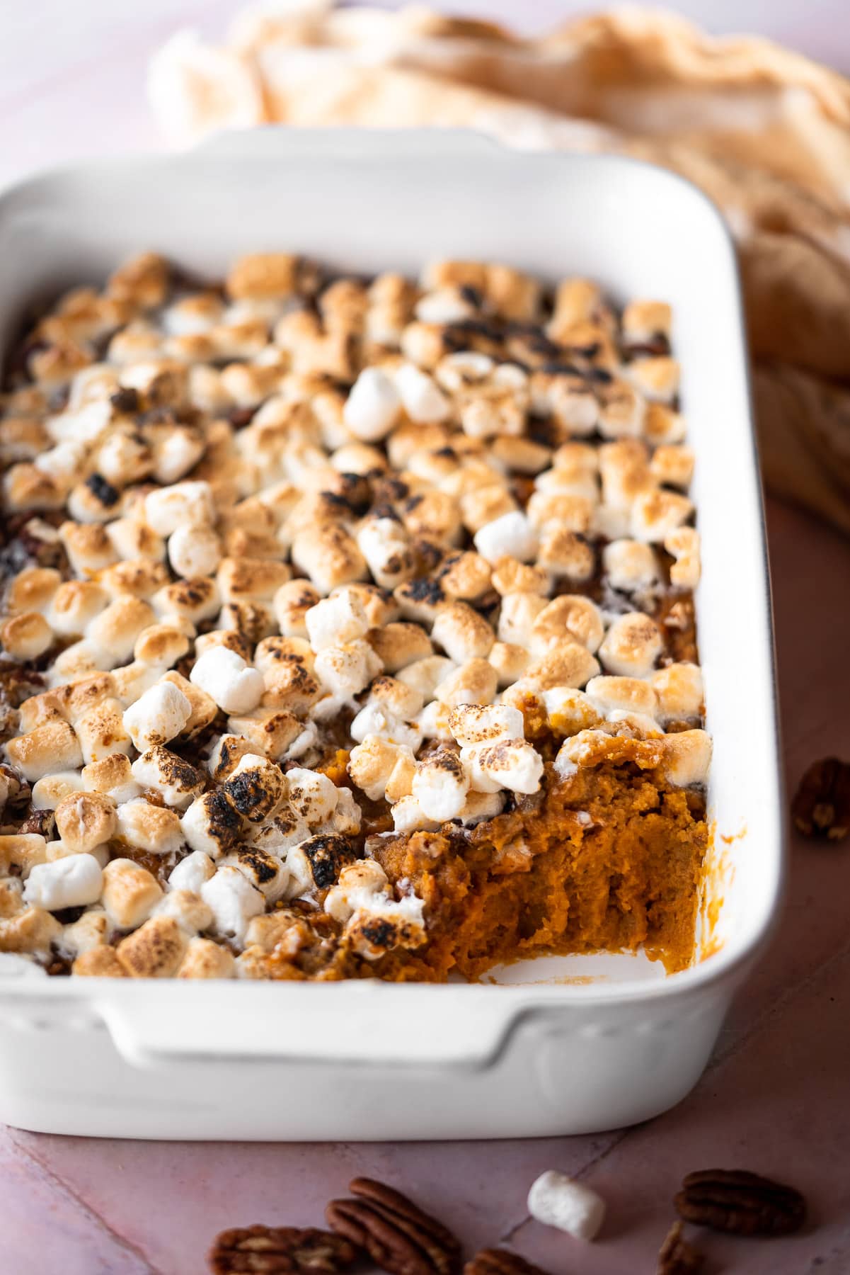sweet potato casserole in a white baker with toasted marshmallow