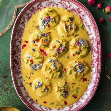 platter full of ras malai with pistachios and flowers