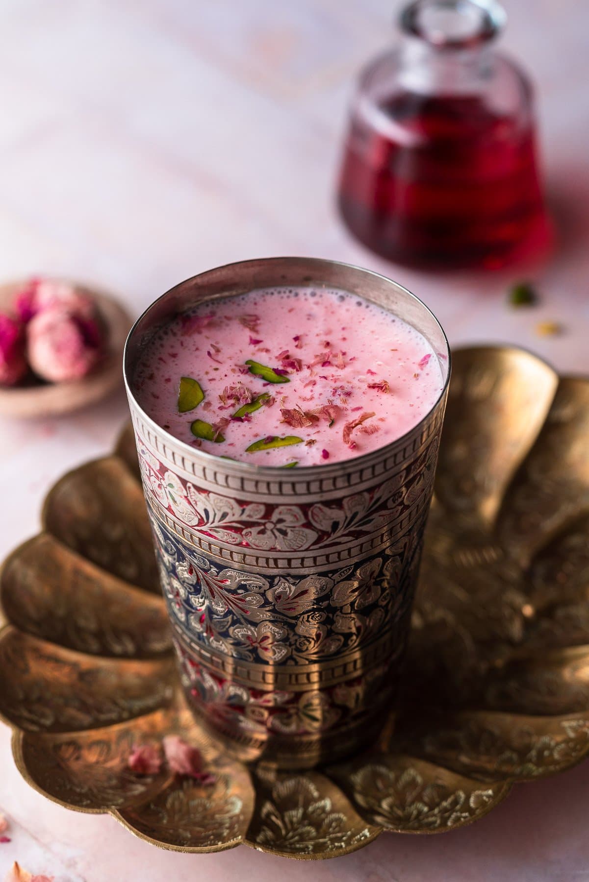 rose lassi in a vintage lassi glass in a brass tray