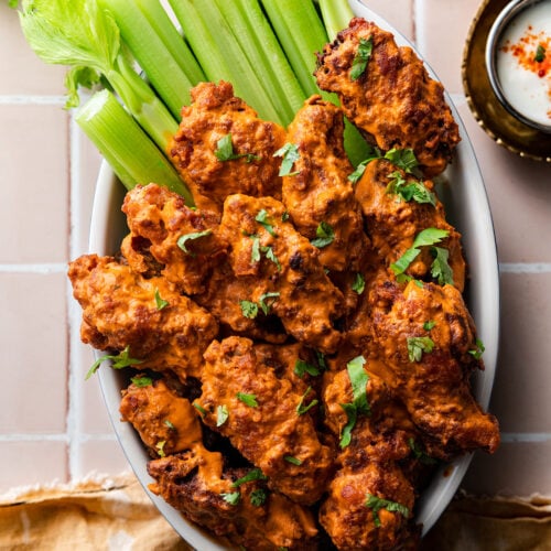 butter chicken wings and celery in a staub baker