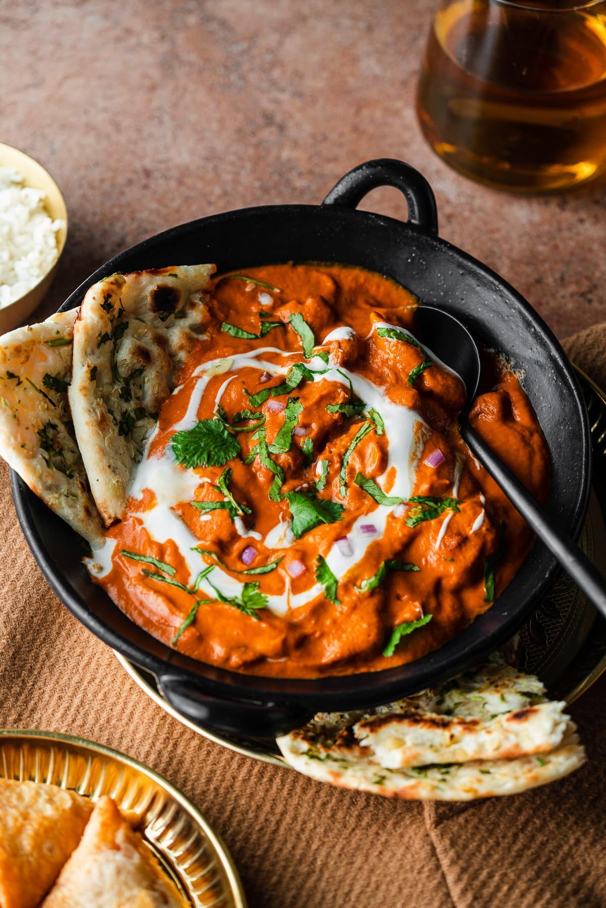 butter chicken in a bowl with garlic naan