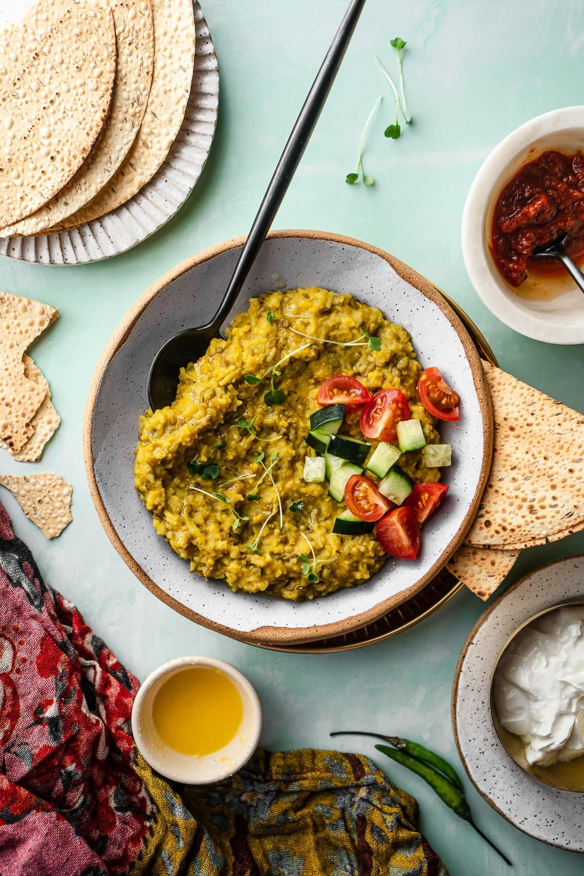 a bowl of khichdi with classic toppings like ghee, dahi, achaar, and papad
