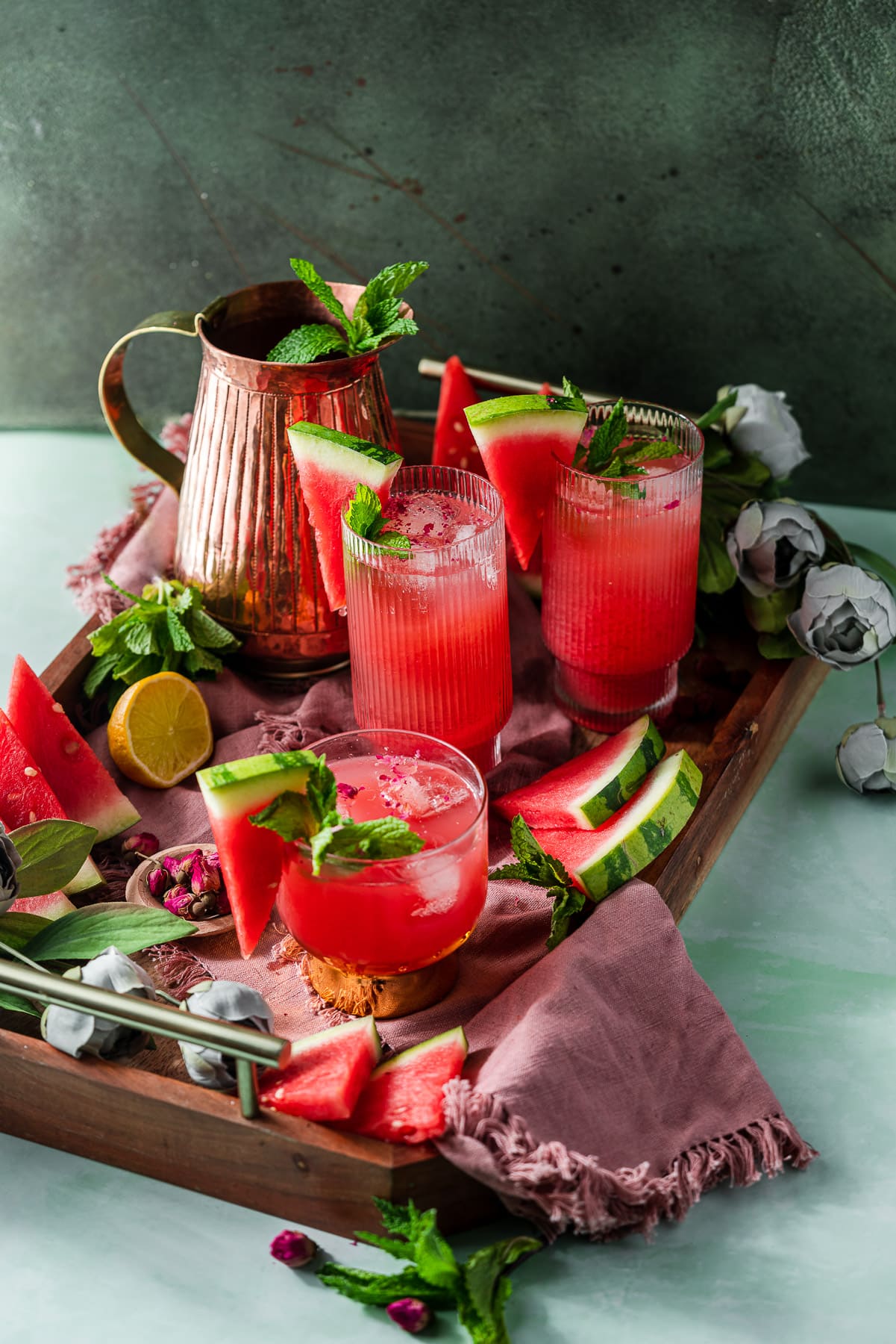 serving tray with watermelon rose coolers, pitcher, florals, and fresh fruit and mint