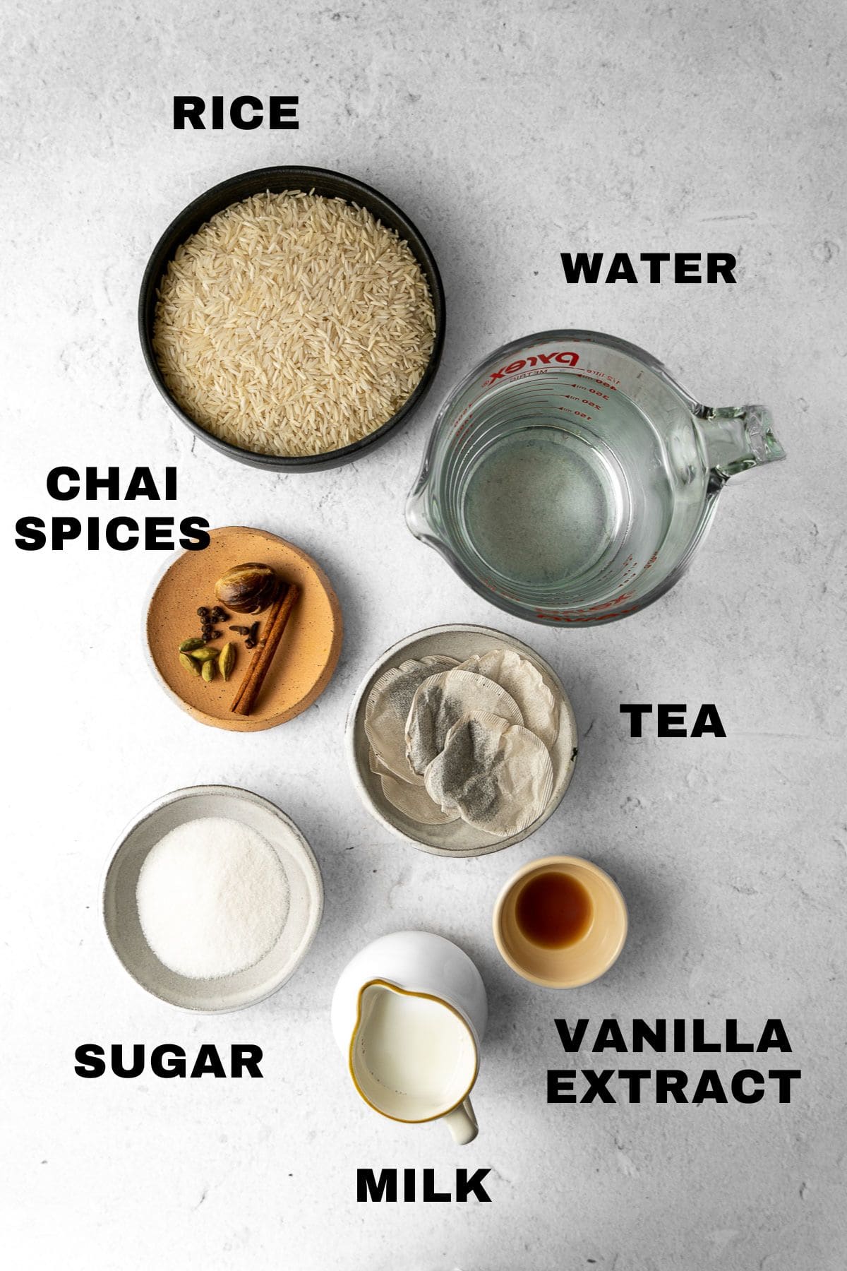 Rice, water, chai spices, tea, vanilla extract, milk, and sugar ingredients pictured with written labels.