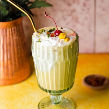 Mango Milkshake in a vintage cup with a copper vase in the back.