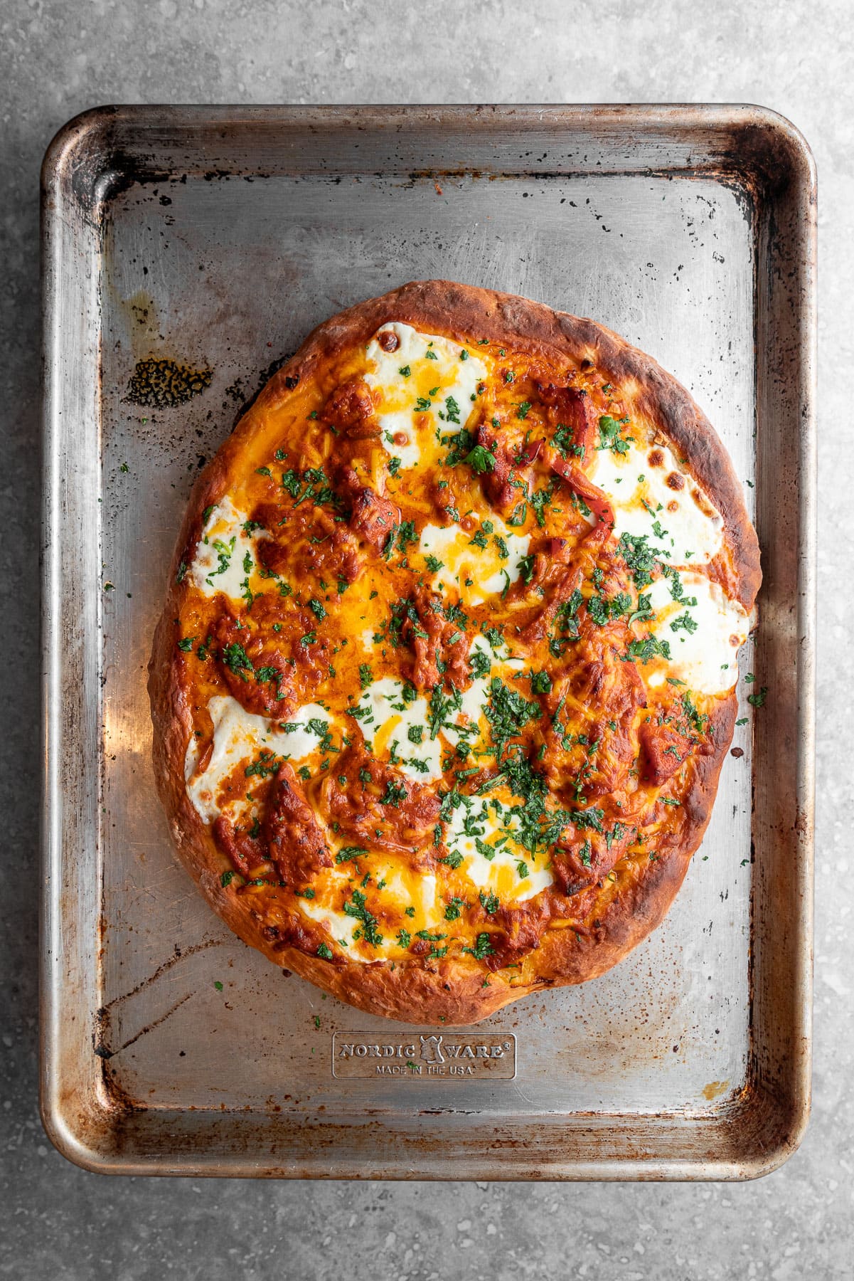 Baked Butter Chicken Garlic Naan Pizza in a sheet tray.