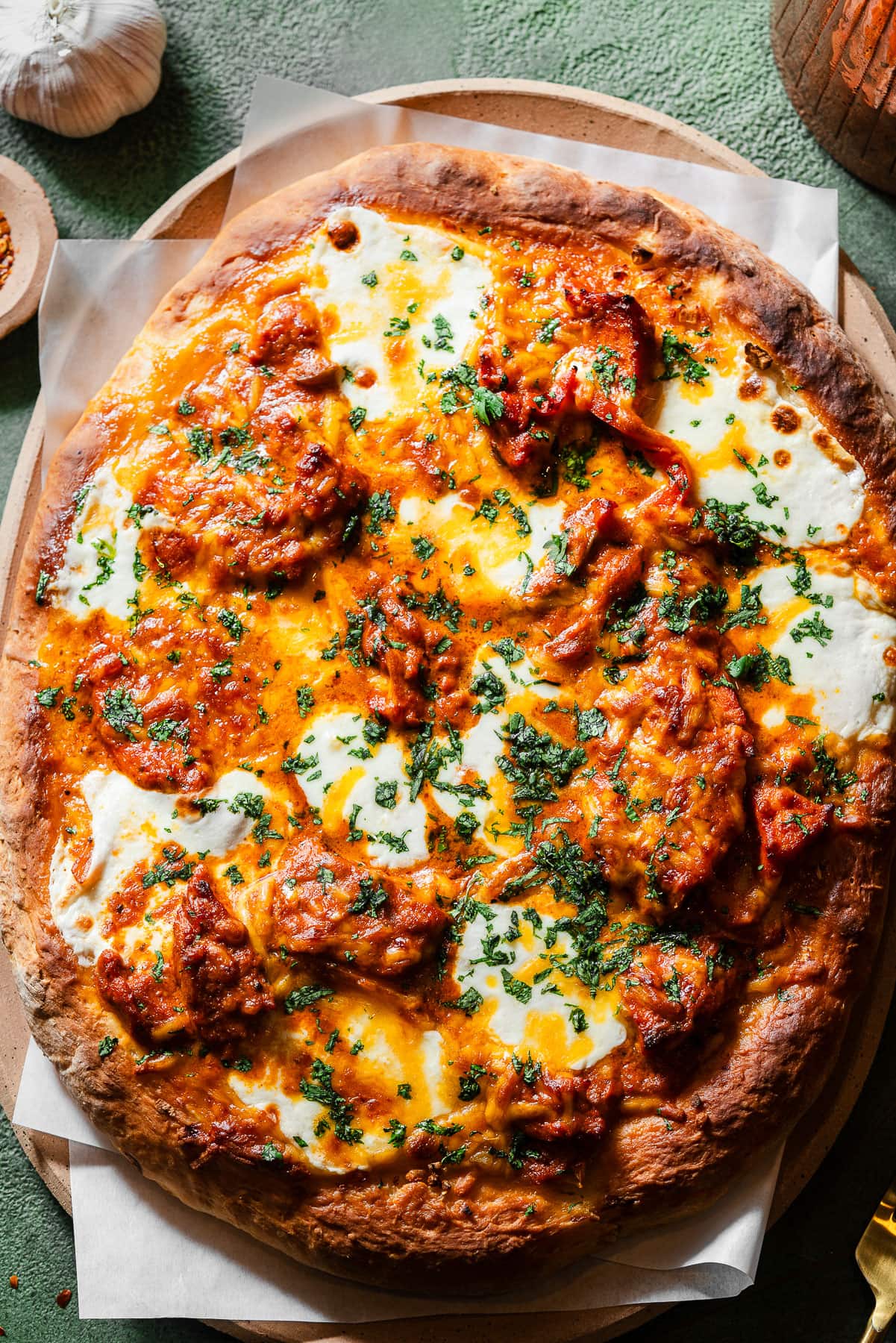 Butter Chicken Garlic Naan Pizza in a serving tray with parchment paper.