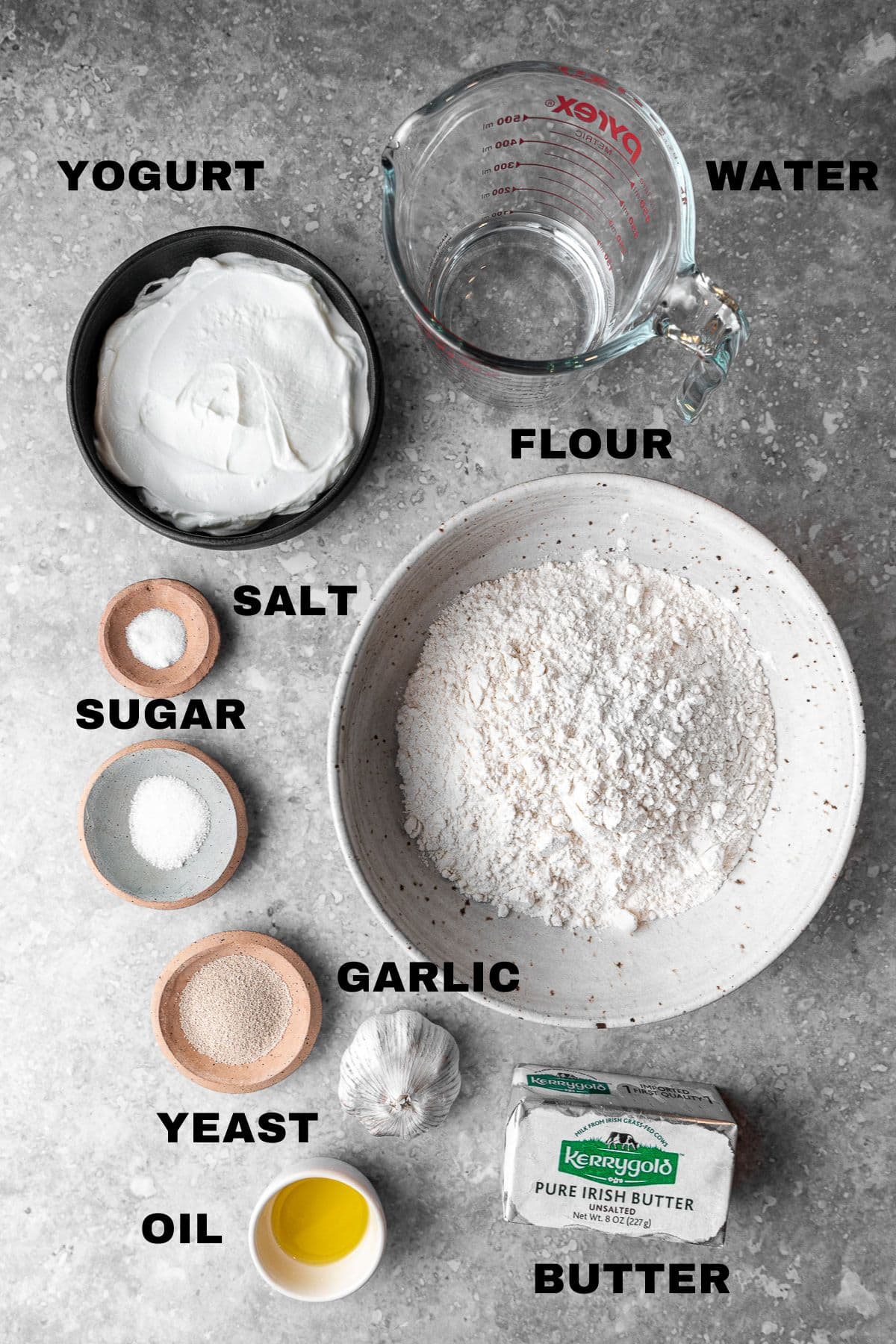 Yogurt, water, flour, salt, sugar, garlic, yeast, oil, butter ingredients with labels.