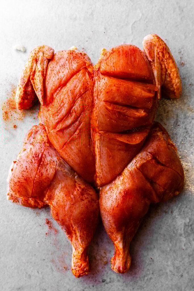 A spatchcock tandoori chicken rubbed with chili powder.