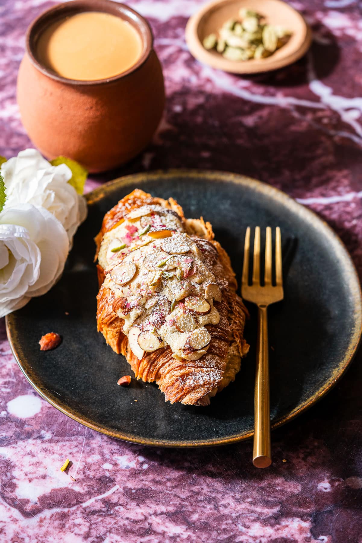 Almond Halwa Croissant in a black plate with a fork.