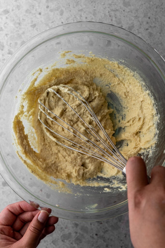 A whisk mixing almond cream.