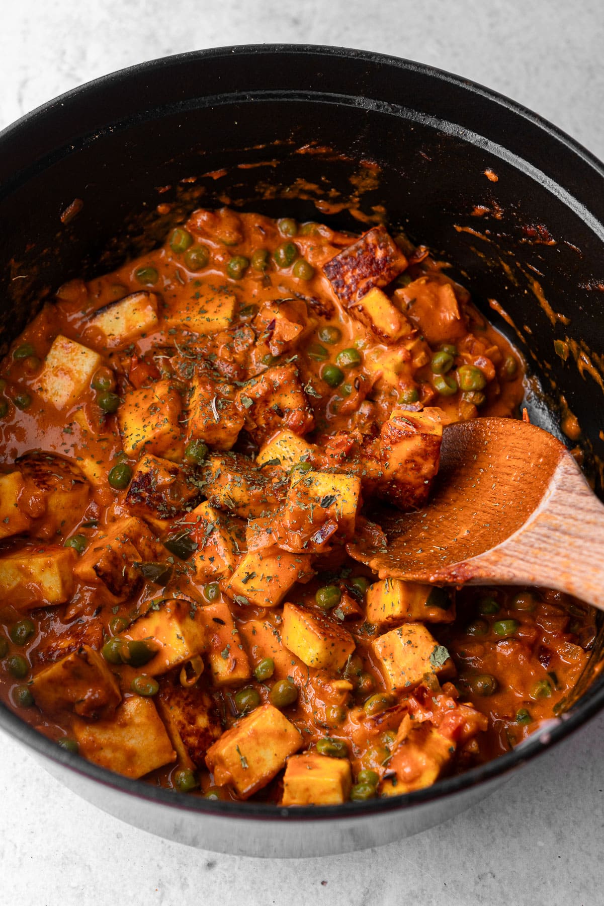 Cooked Mattar Paneer in a dutch oven topped with kasuri methi.