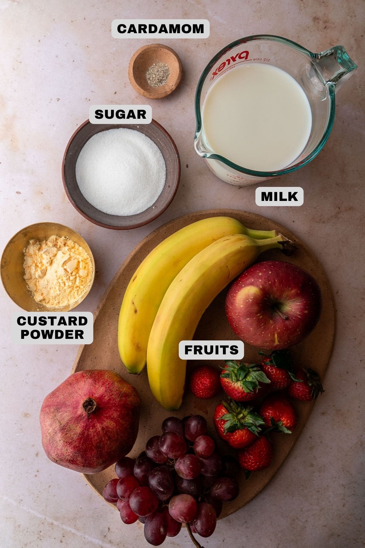 Cardamom, milk, sugar, custard powder, fruit ingredients with labels.