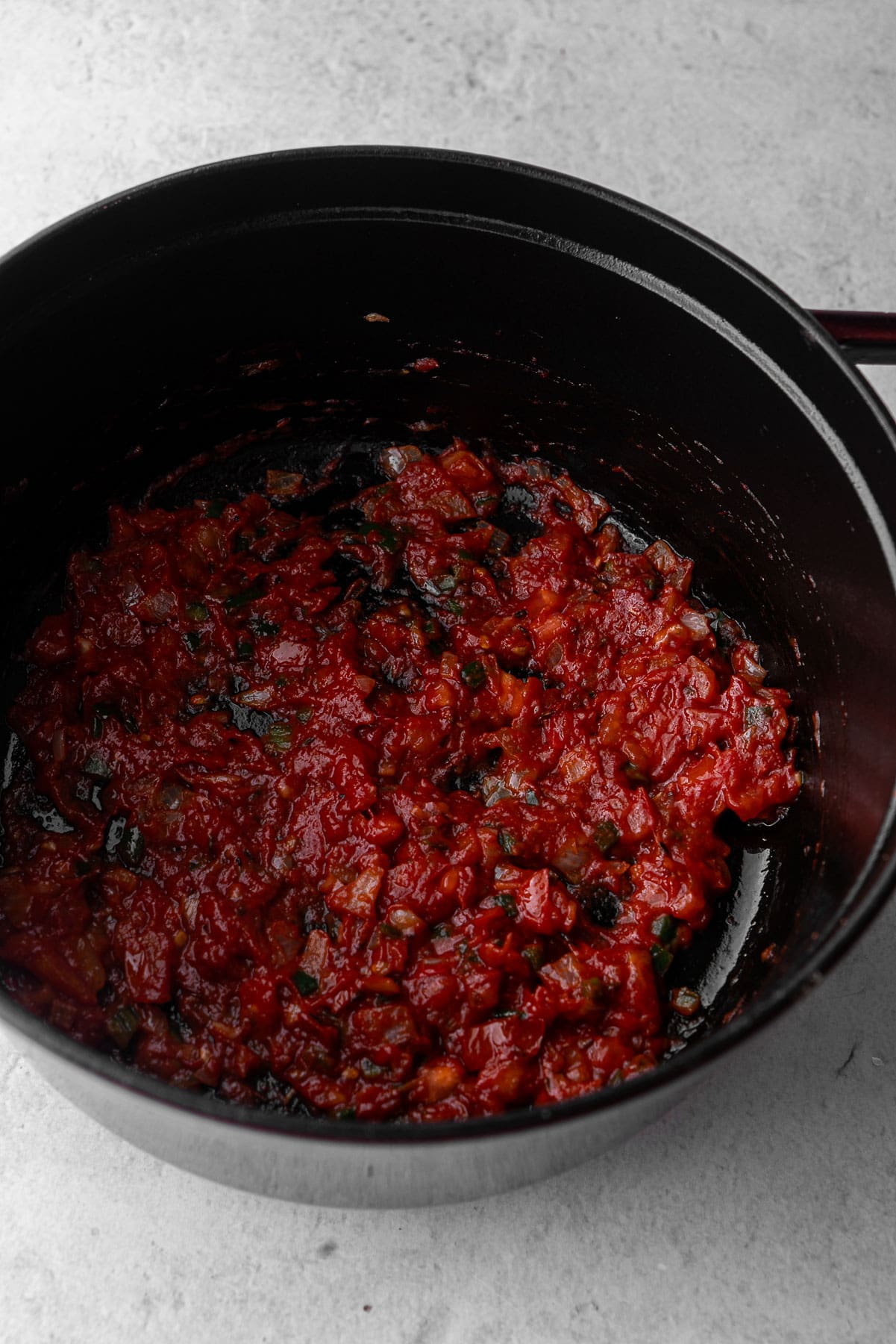 Cooked down tomato, onion, chili, ginger garlic paste in a dutch oven.