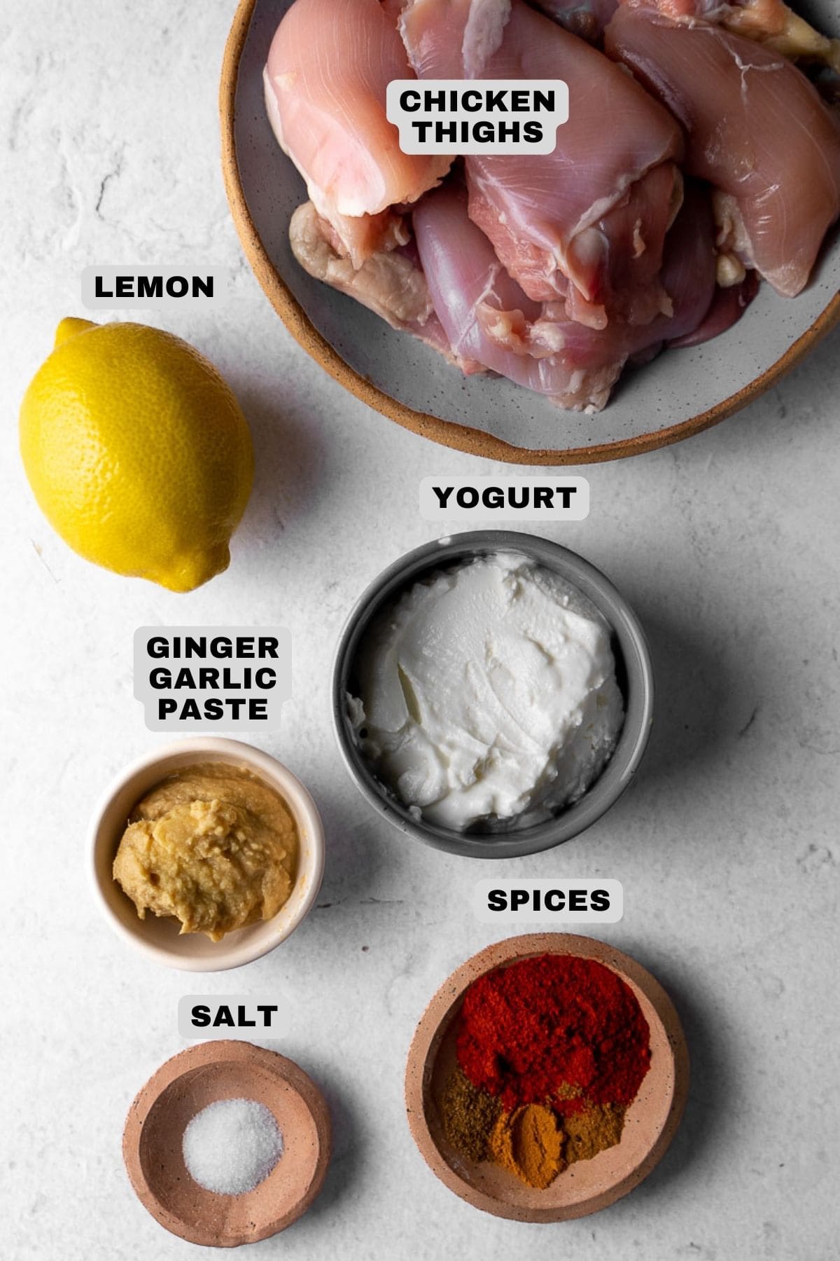 Chicken thighs, lemon, yogurt, ginger garlic paste, spices, salt ingredients with labels.