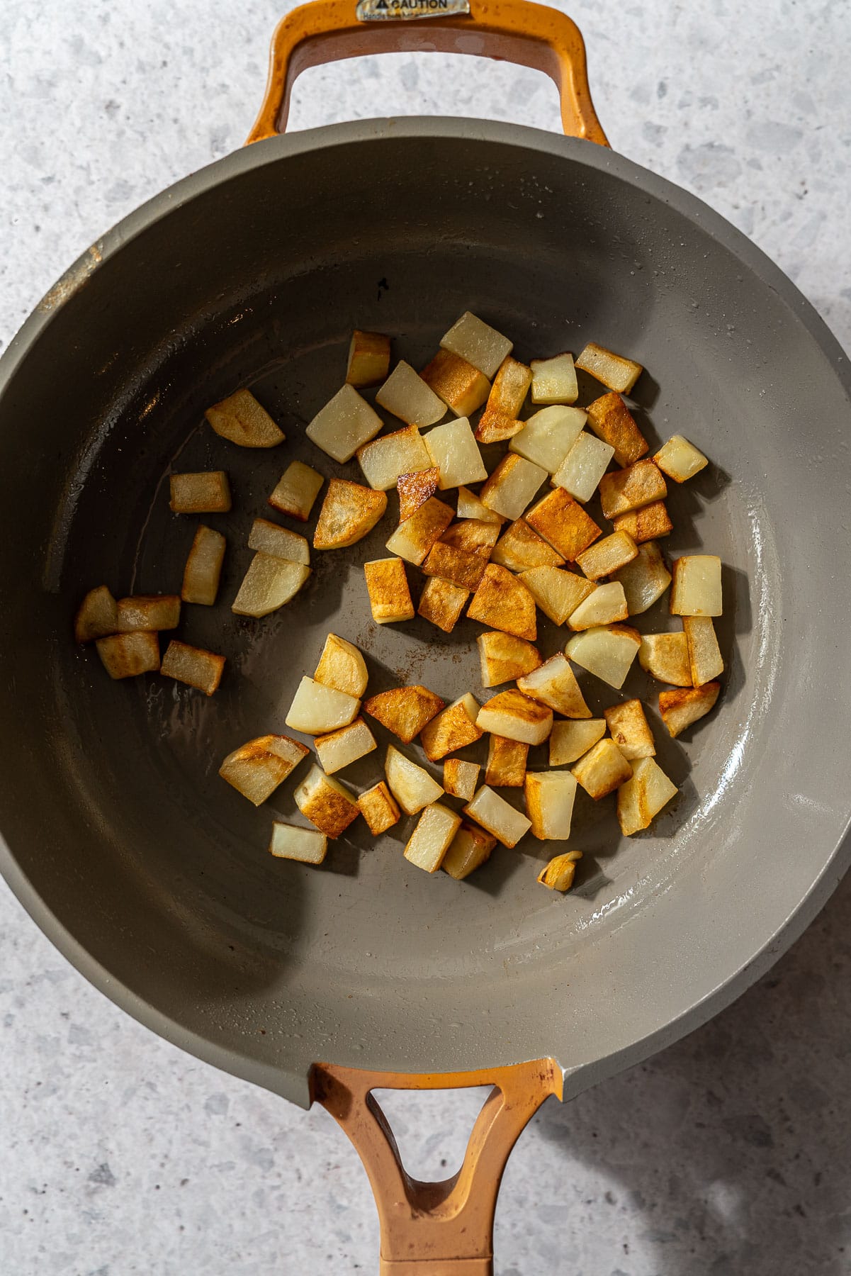 A pan with pan-fried crispy diced potatoes.