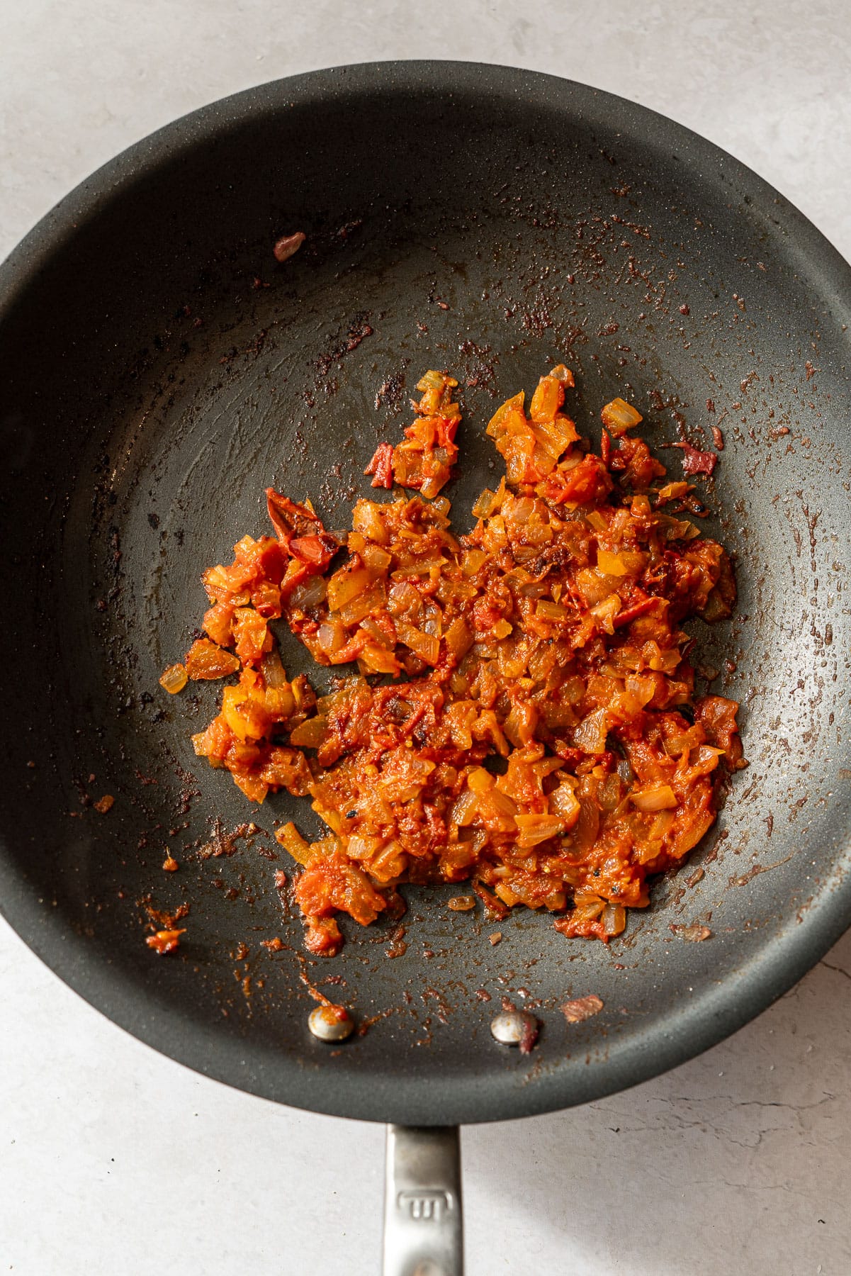 Cooked onions and tomatoes masala in a pan.