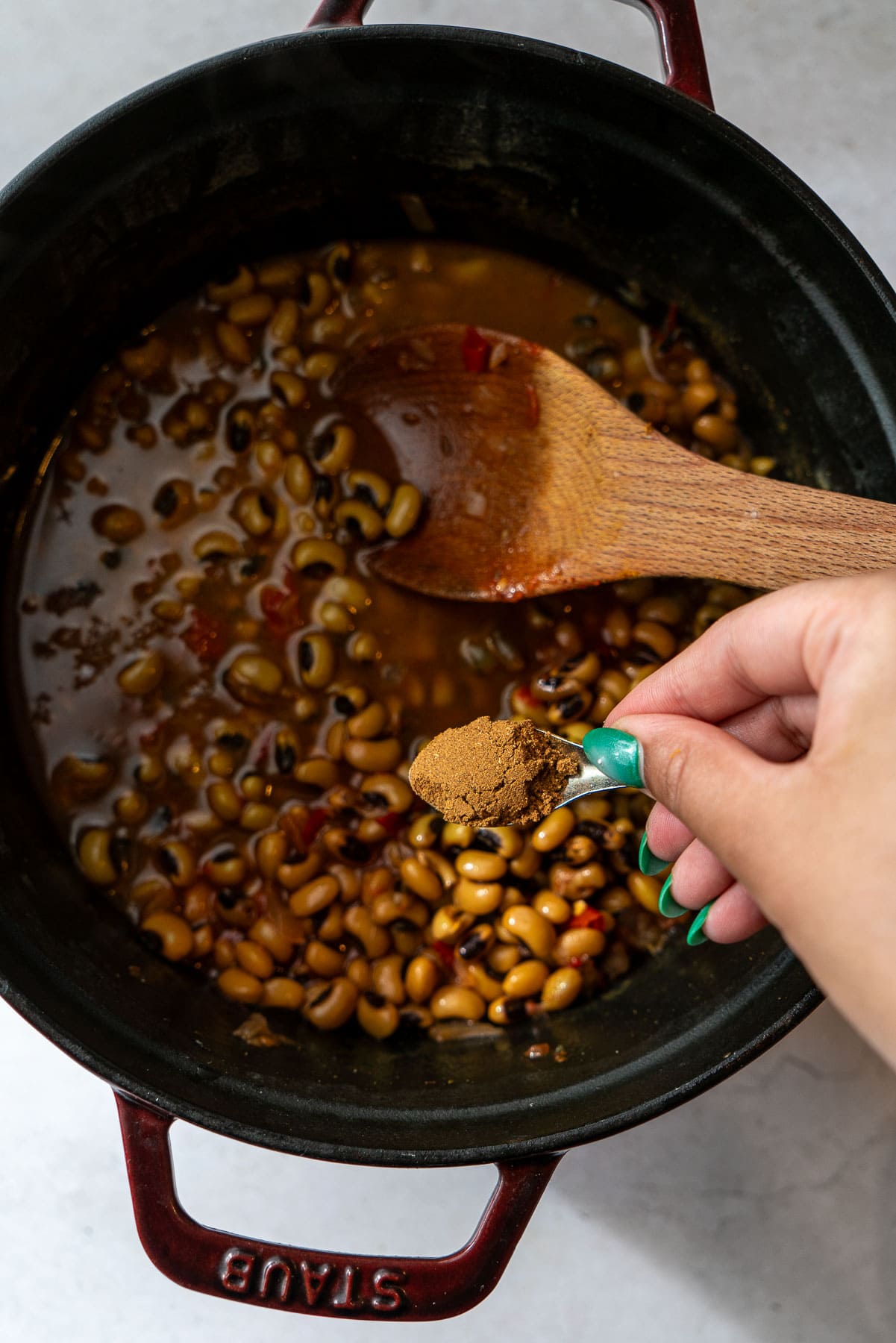 Adding garam masala as a finisher for a cooked black eyed peas curry.