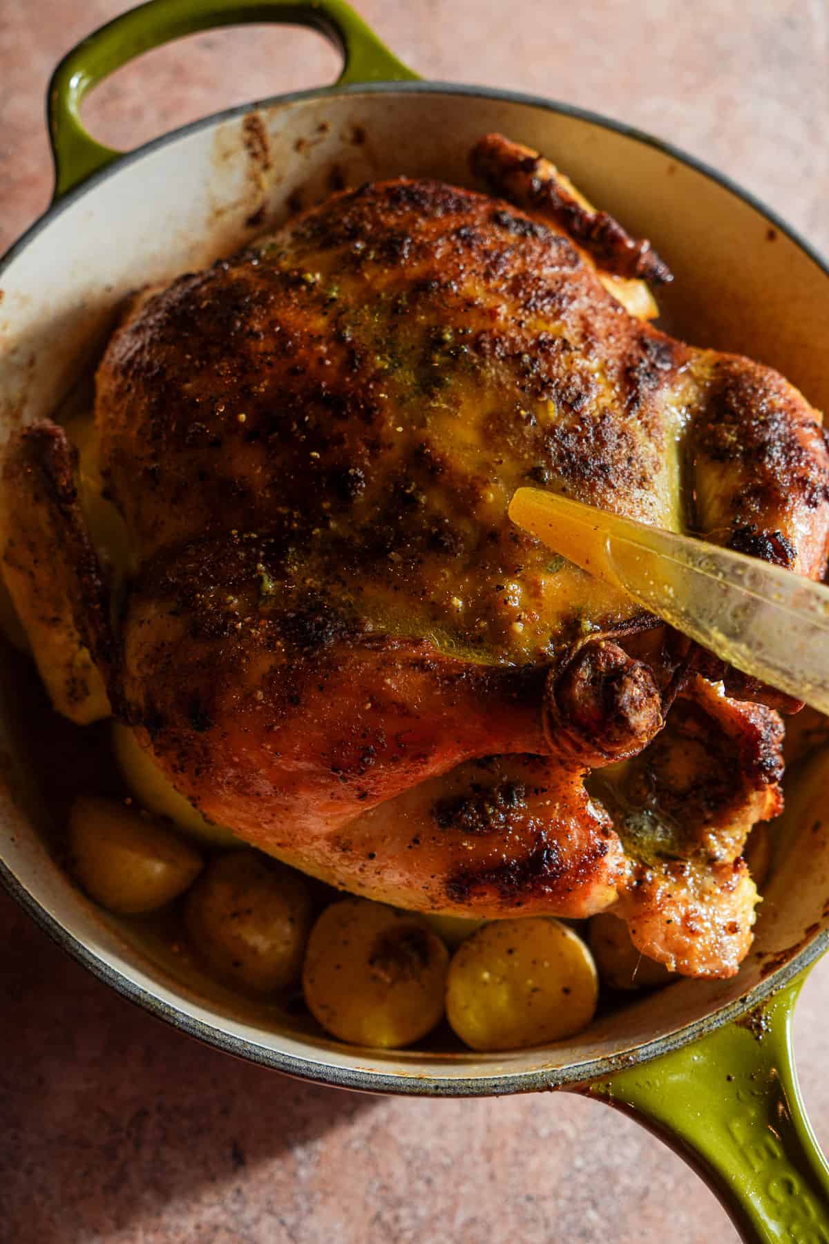 Basting a roast chicken with a baster.