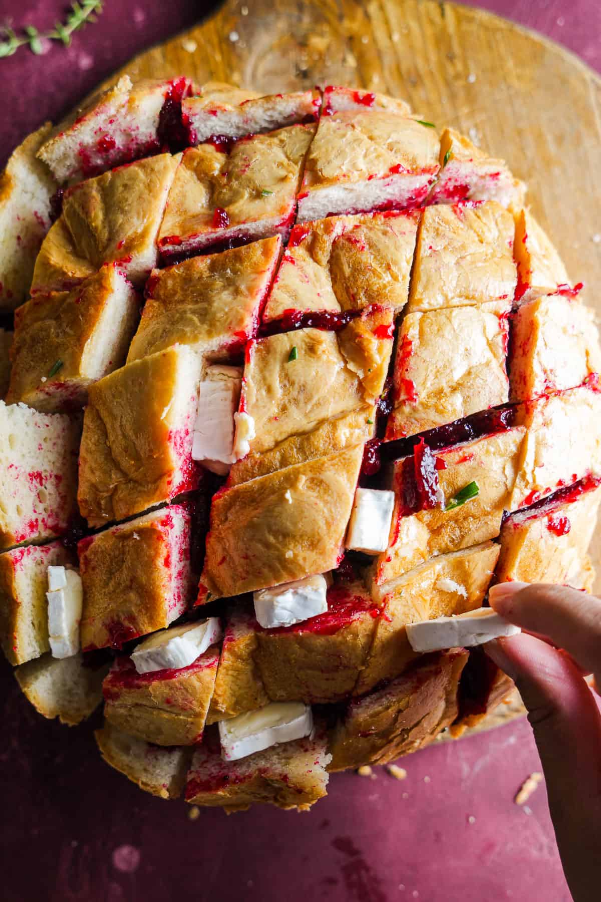 Hand stuffing brie into sliced bread