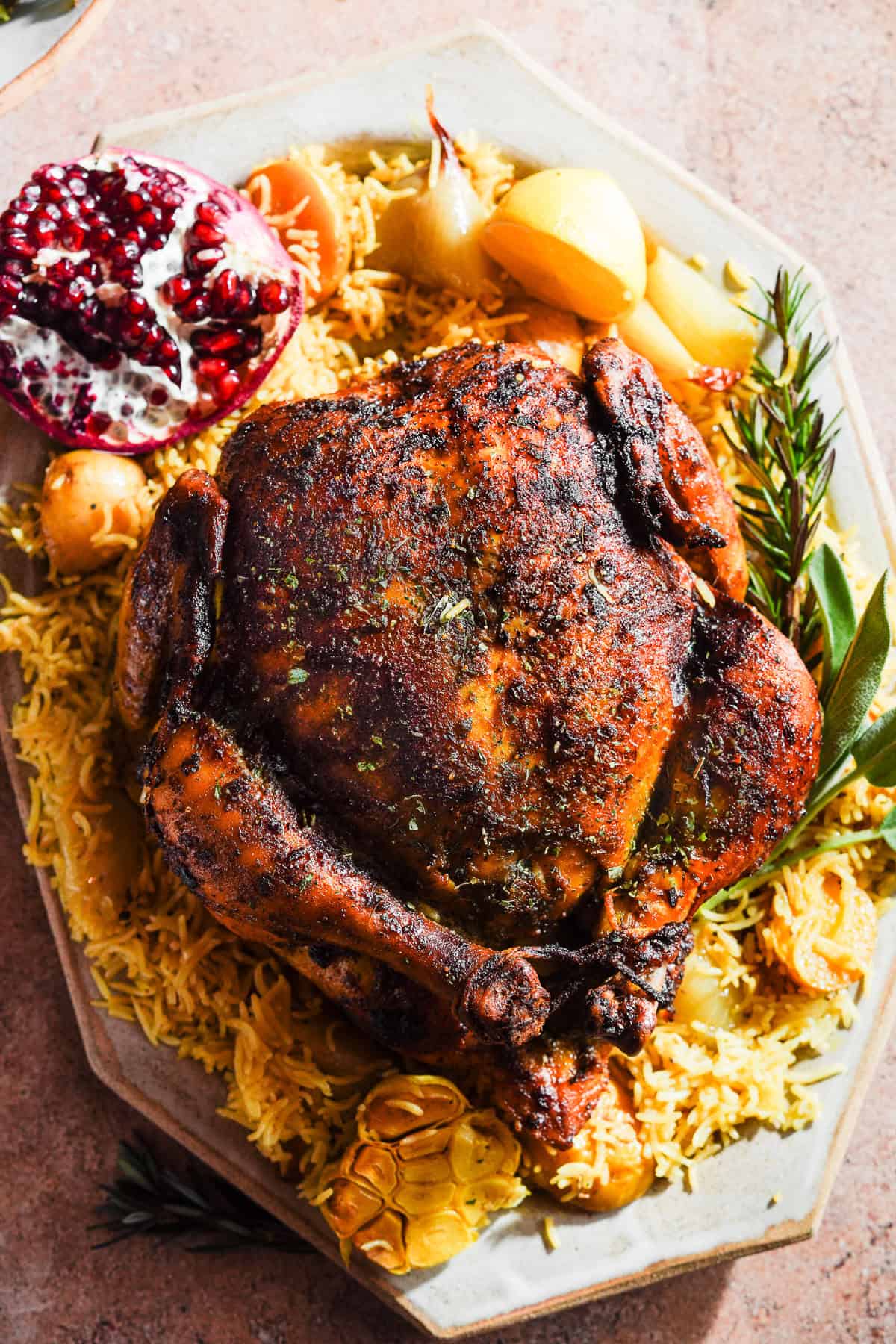 Curried Chicken on top of a bed of rice with potatoes and herbs on a platter.