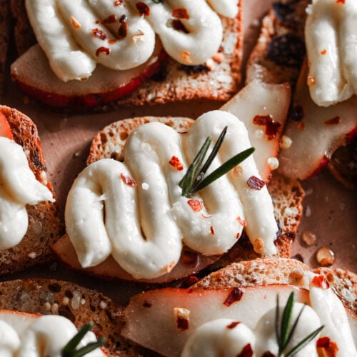 Pear and whipped brie on crackers in a platter.