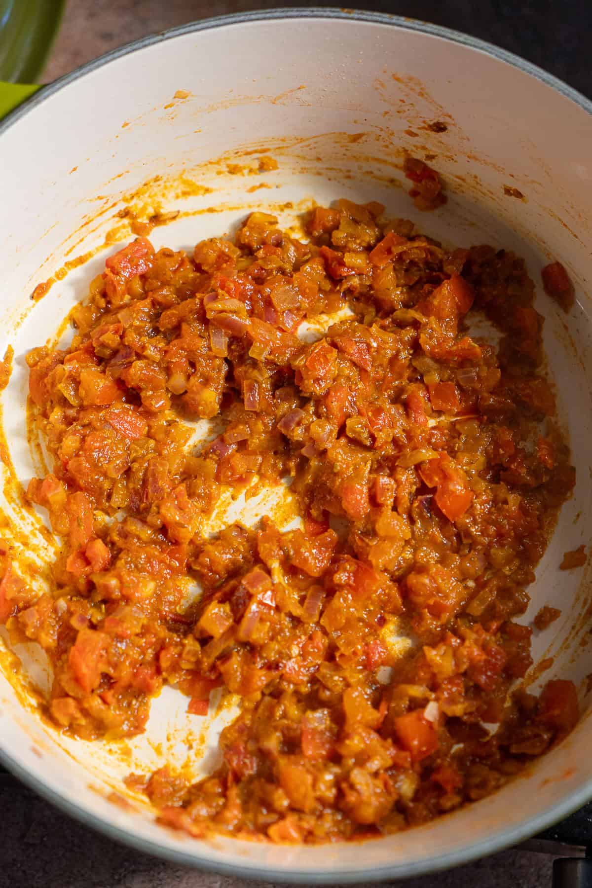 A dutch oven with a tomato onion masala.