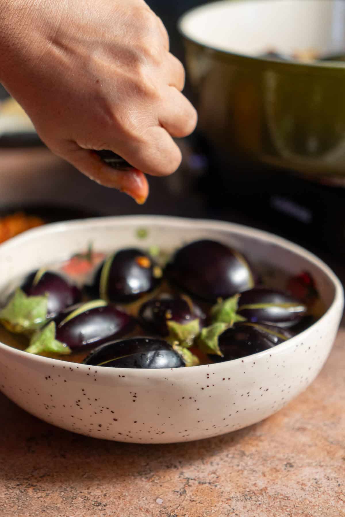 Squeezing the water out of an eggplant that was soaking in water.
