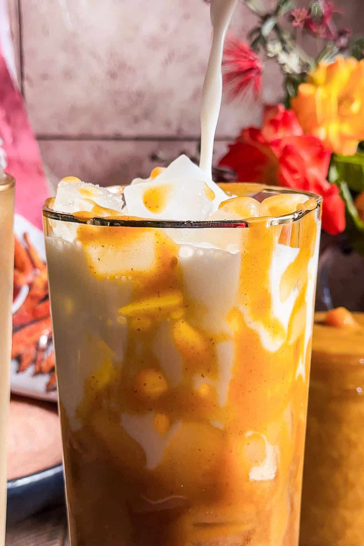 Pouring milk into a sweet potato latte.