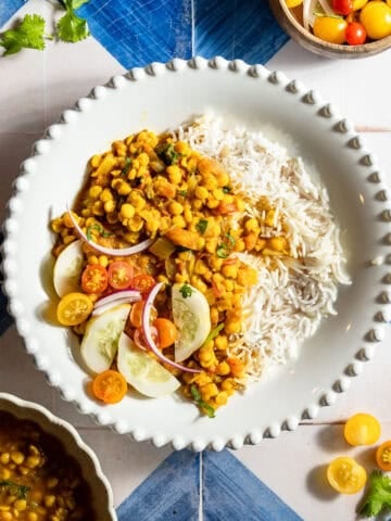 Chana dal with rice with an onion, tomato, and cucumber side salad.