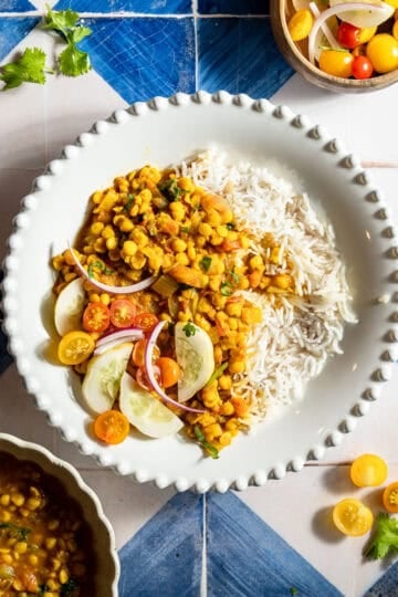 Chana dal with rice with an onion, tomato, and cucumber side salad.