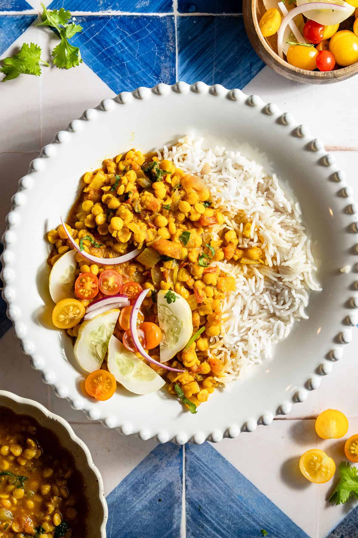 Chana dal with rice with an onion, tomato, and cucumber side salad.