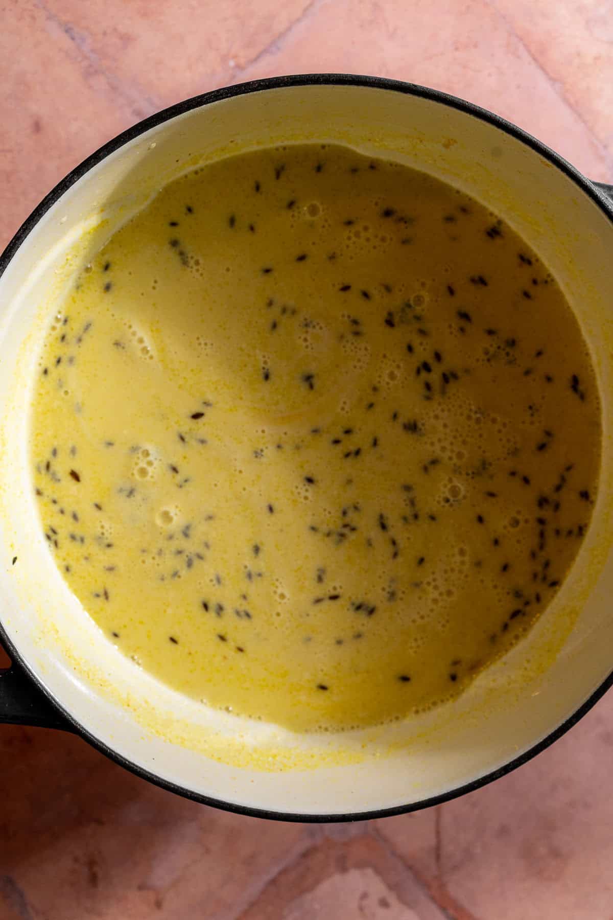 A dutch oven with the yogurt base and spices for kadhi.