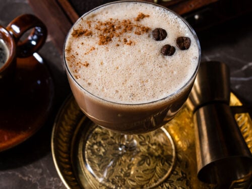 A chai espresso martini in a plate with a chai spice box.