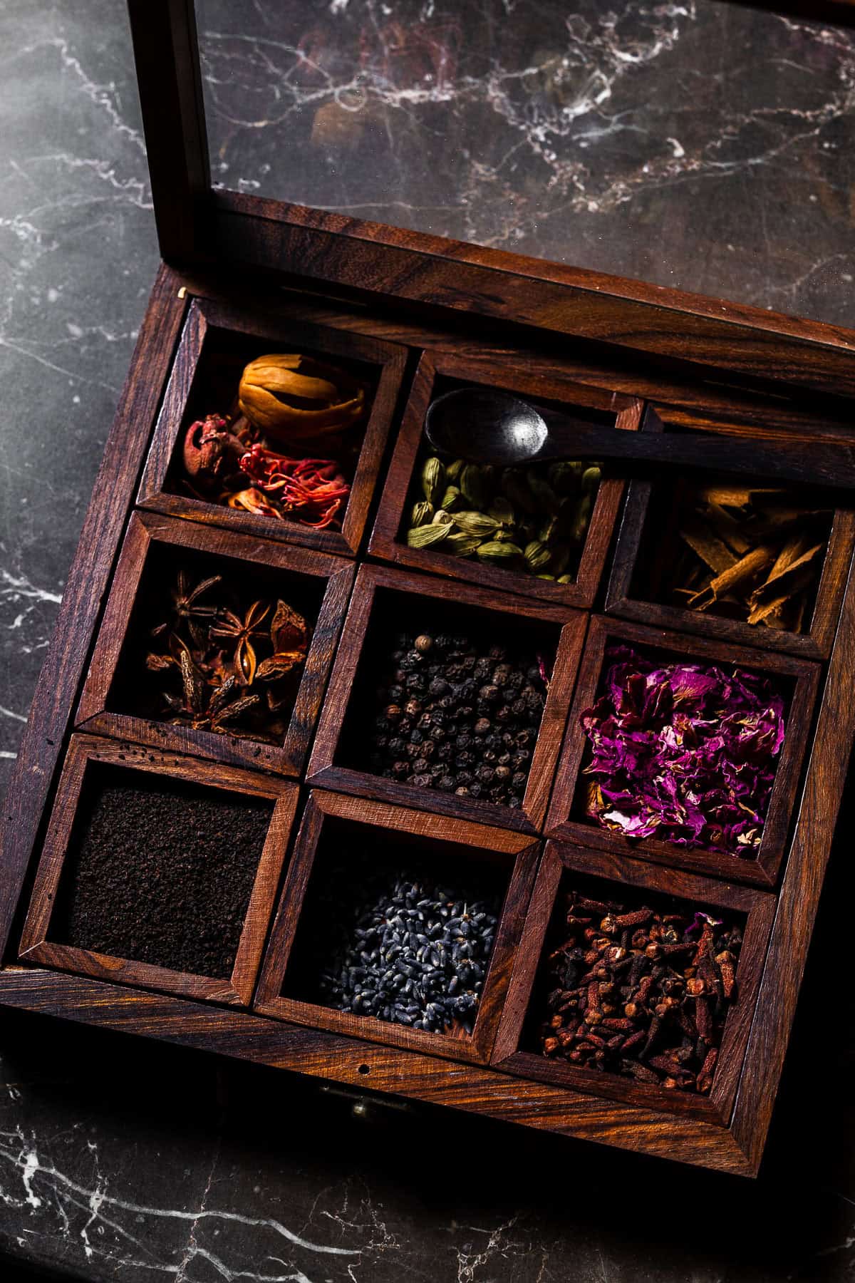A spice box with compartments full of whole spices for chai.