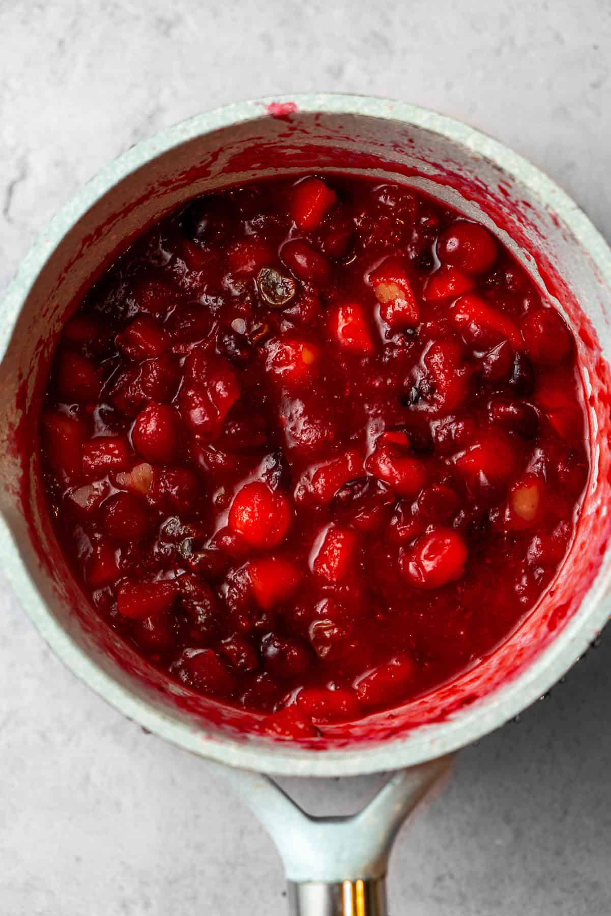 Chunky cranberry chutney reducing in a pot.