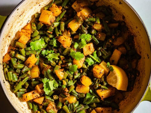 Green beans aloo sabzi in a dutch oven with a side of kachumber salad.