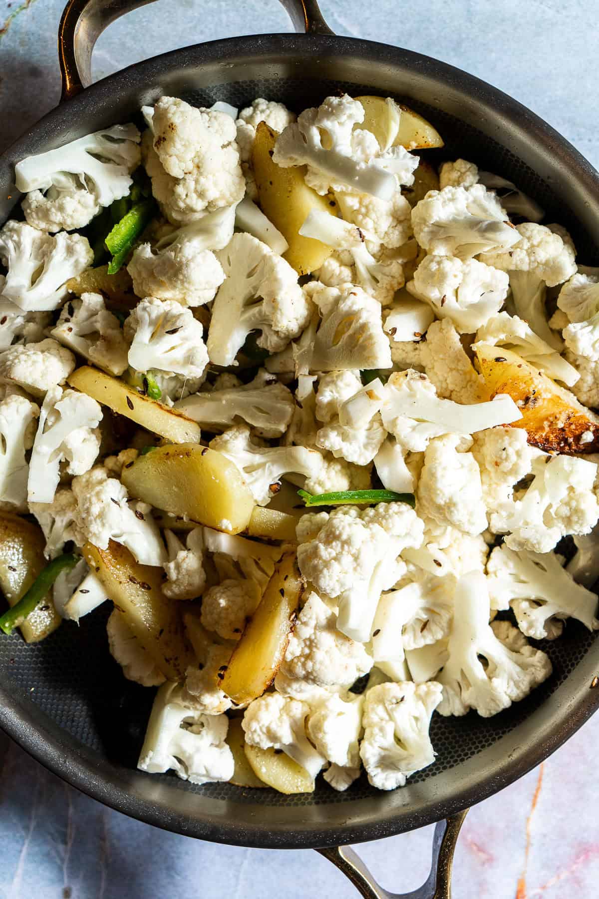 Sauteed potatoes with raw cauliflower.
