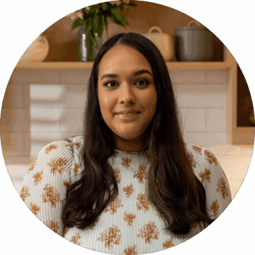 Headshot of Shweta in a kitchen with a floral dress.