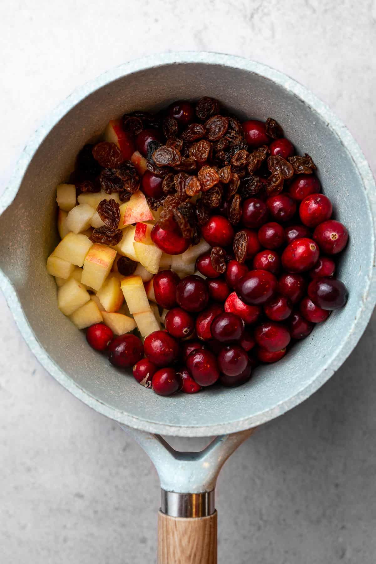Ingredients for cranberry chutney beginning to simmer in a sauce pan.