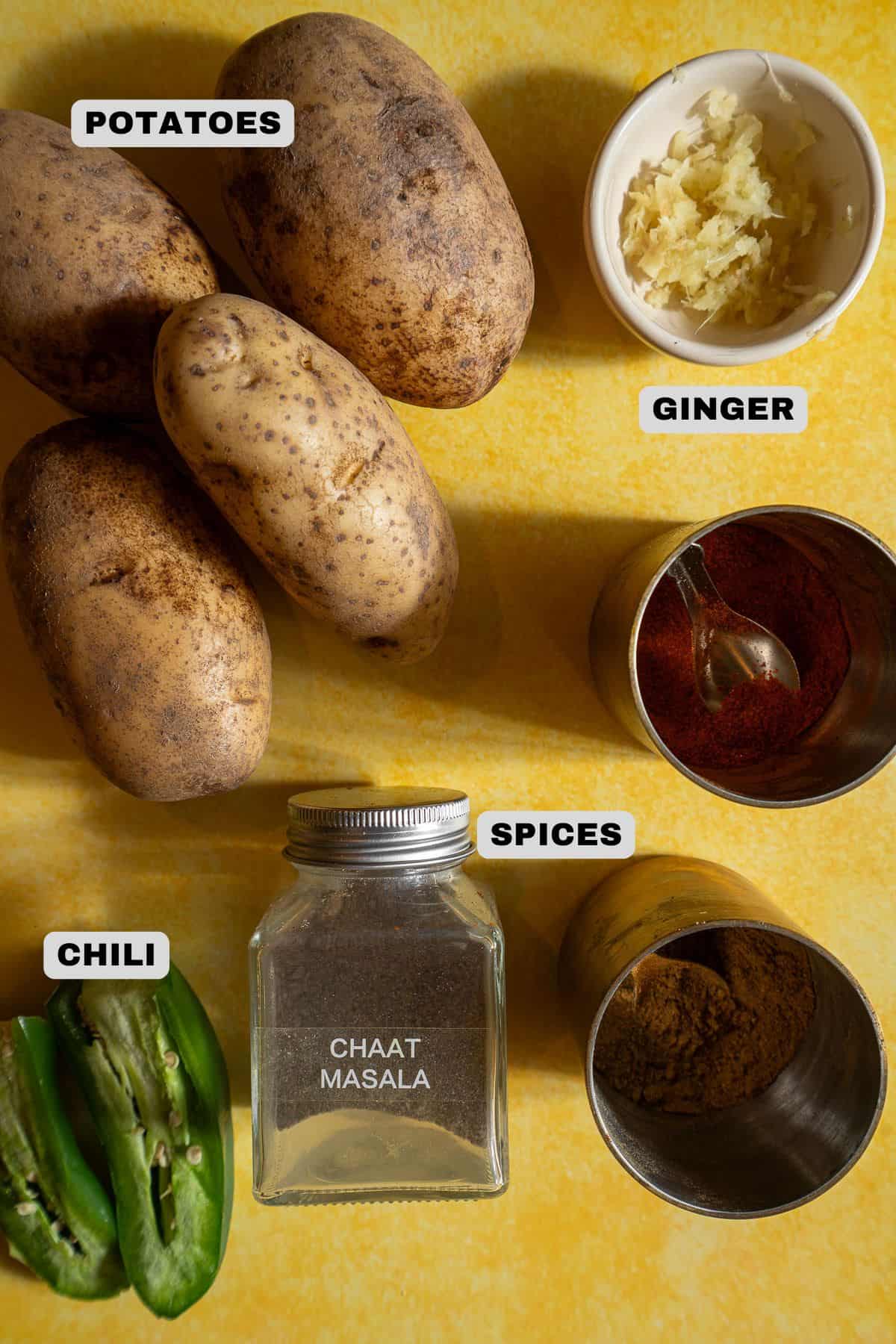 Potatoes, ginger, spices, chili ingredients with labels.