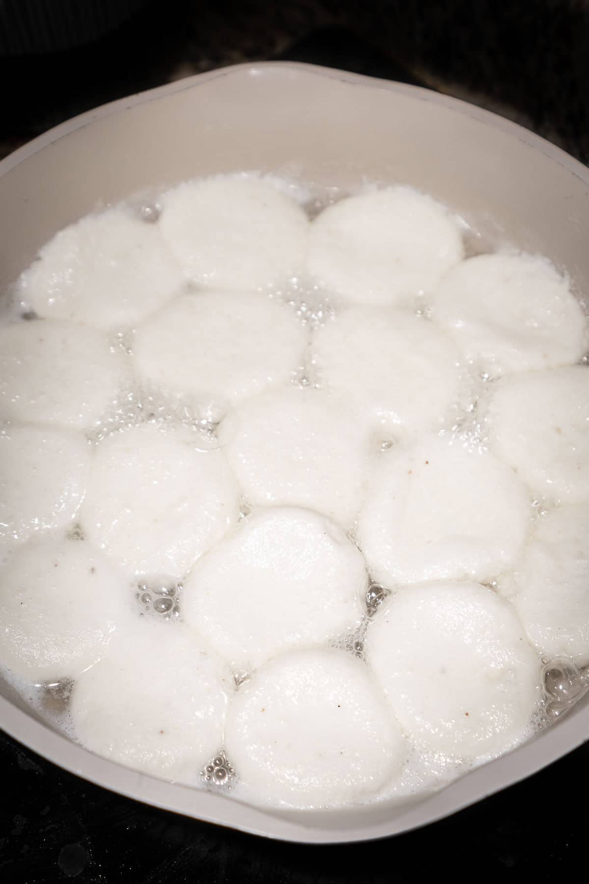 Boiled paneer chenna dumplings doubled in size in sugar water.