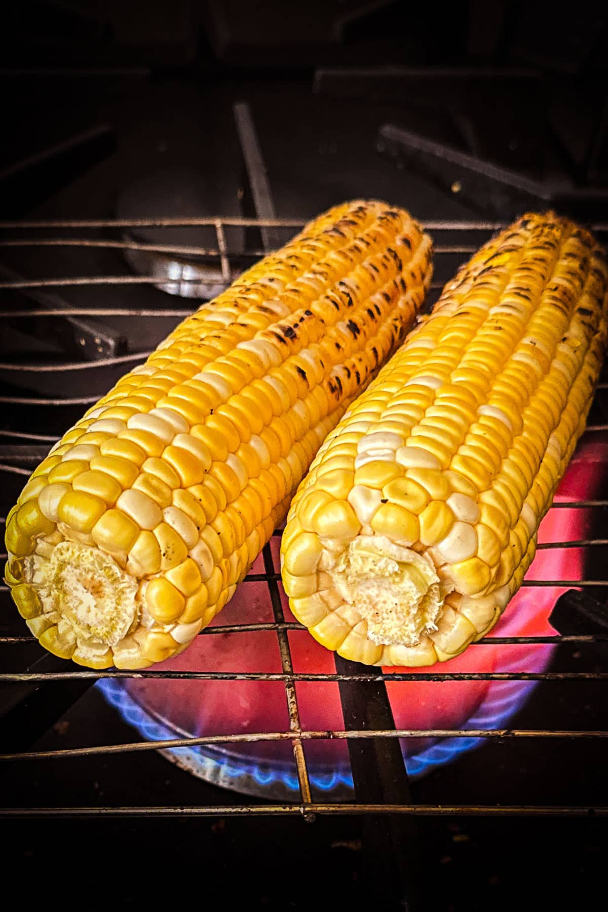 Corn grilling over an open flame.