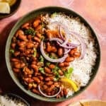 Rajma in a bowl with rice and red onions.