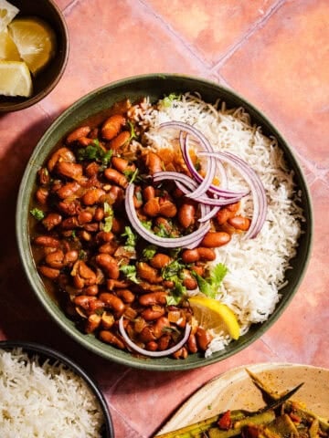 Rajma in a bowl with rice and red onions.