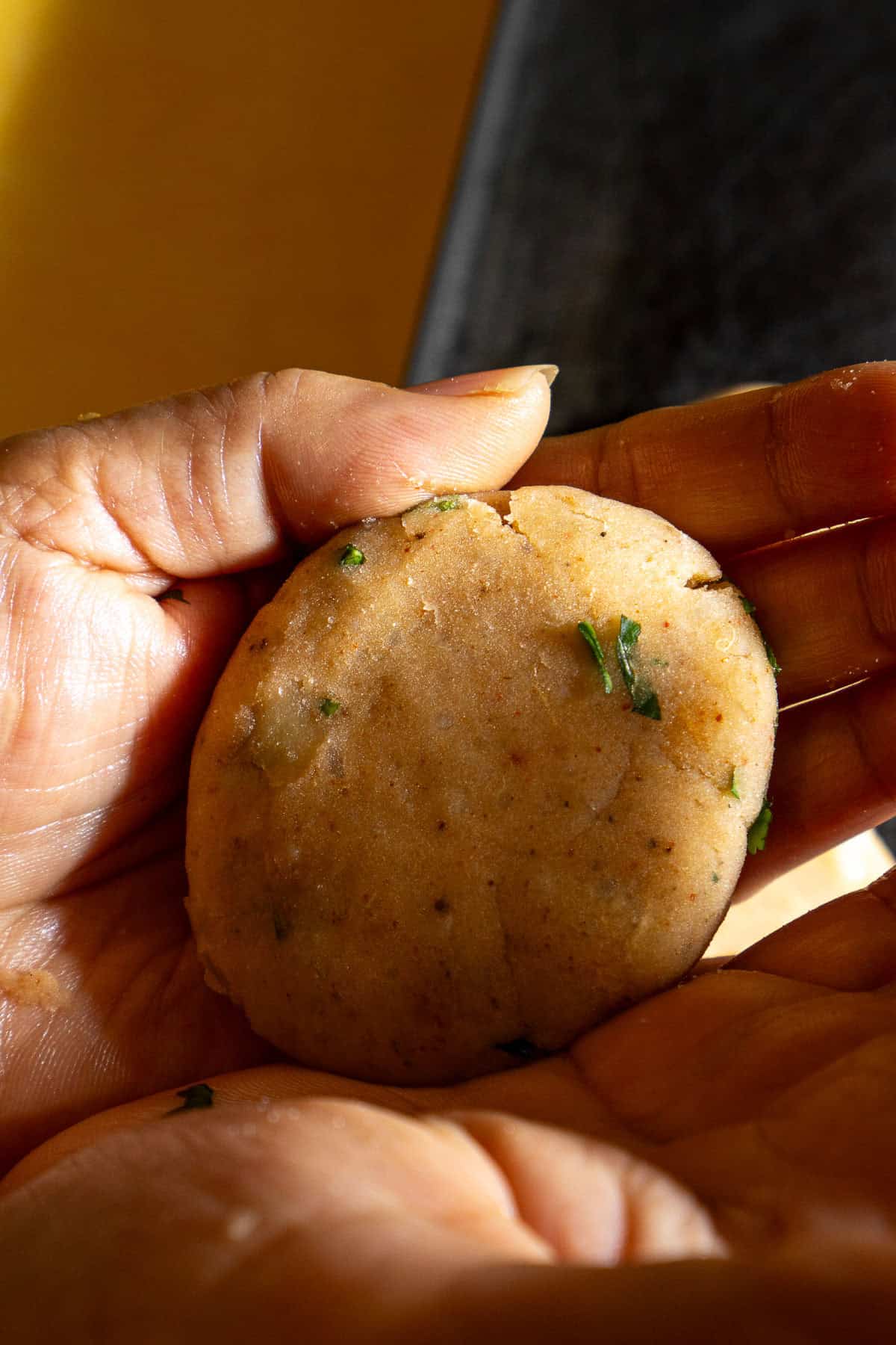 Forming a round aloo tikki patty.