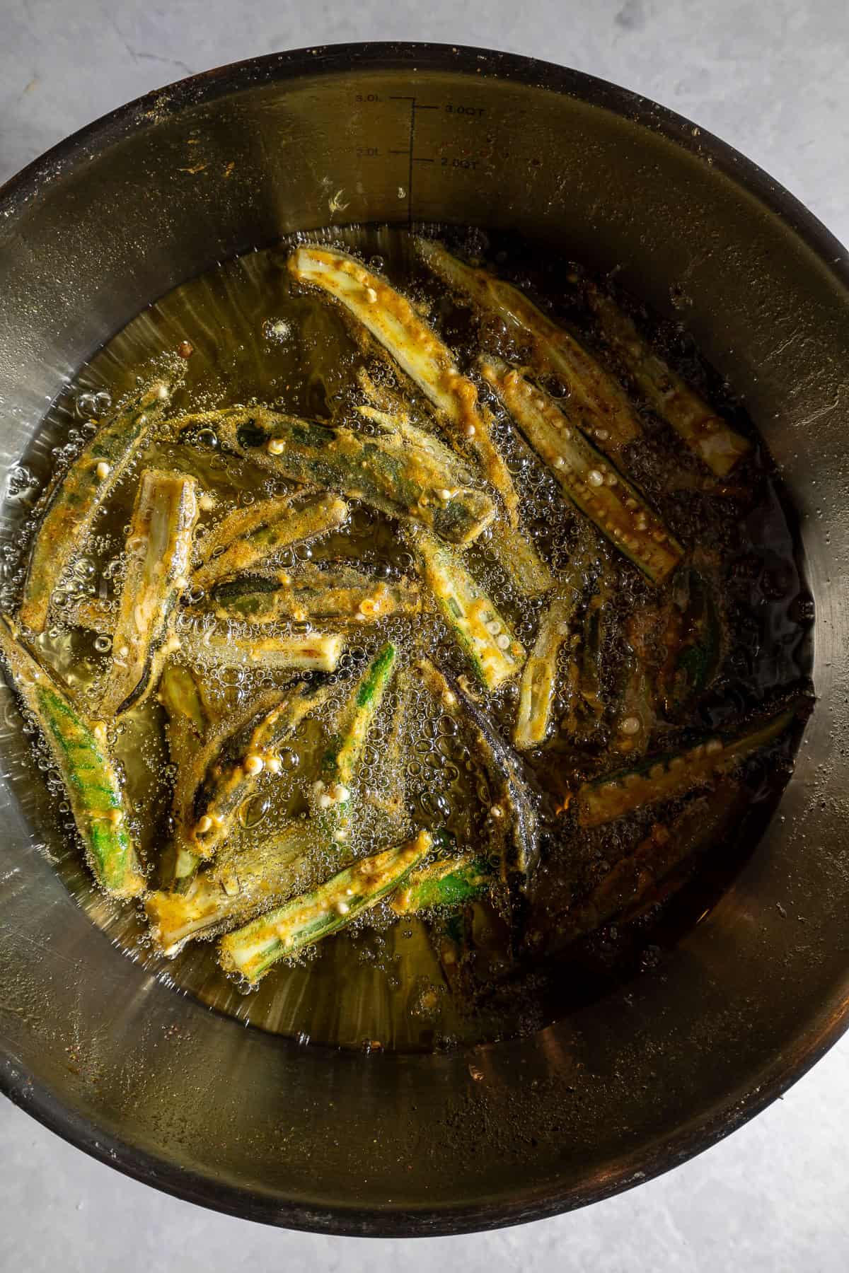 Battered okra frying in oil.