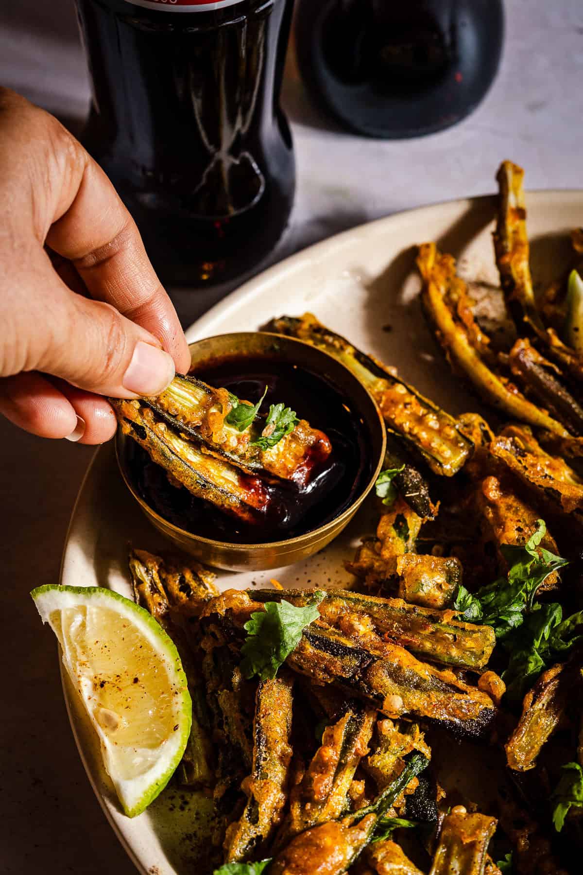 Dipping kurkuri bhindi in chutney.