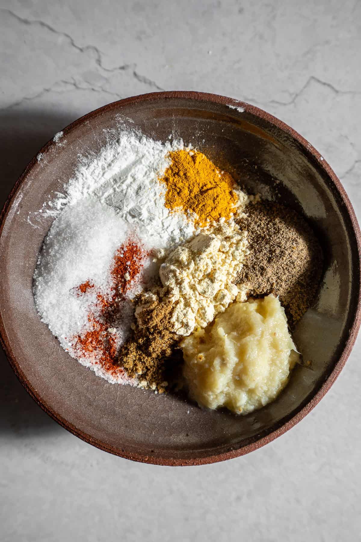 Unmixed batter for kurkuri bhindi with spices, flours, and ginger garlic paste.